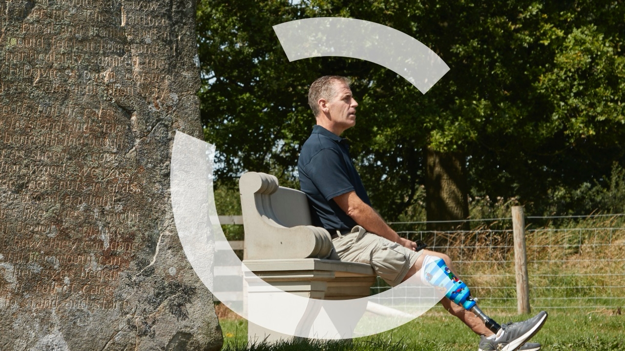 Man with prosthetic leg sat outside