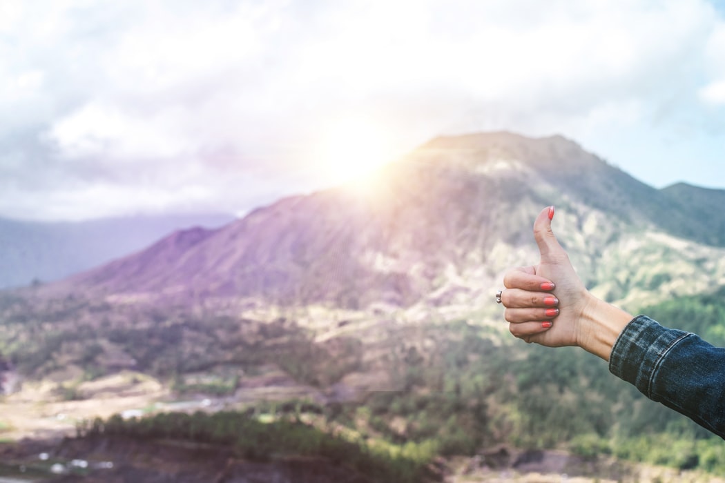 Picture of a thumbs up with the backdrop of a mountain