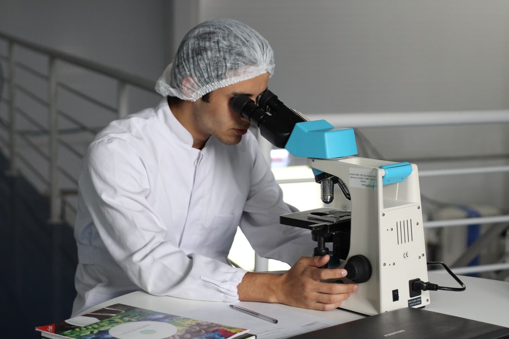Picture of a scientist looking into a microscope