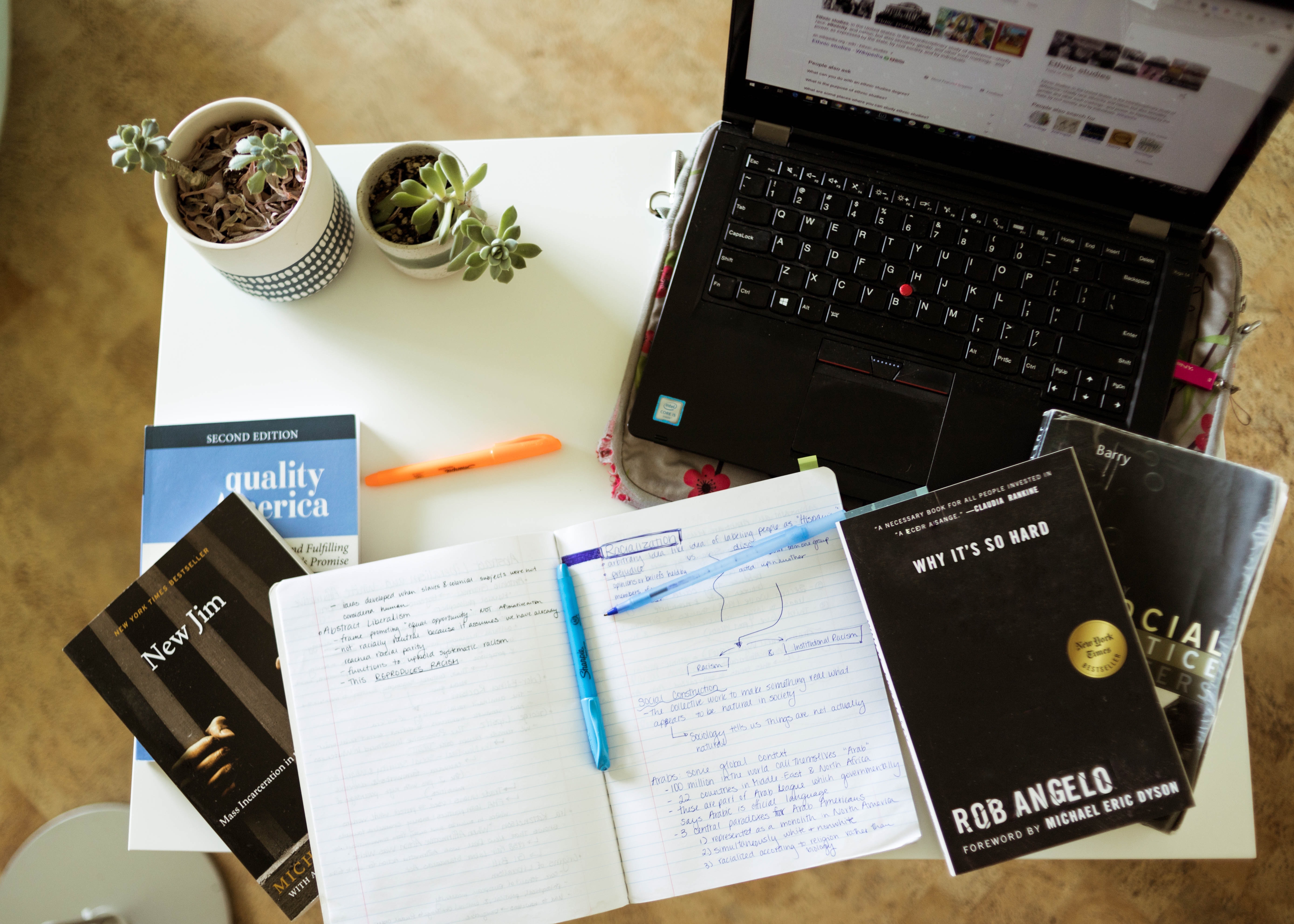 Picture of a laptop and notebooks on a desk